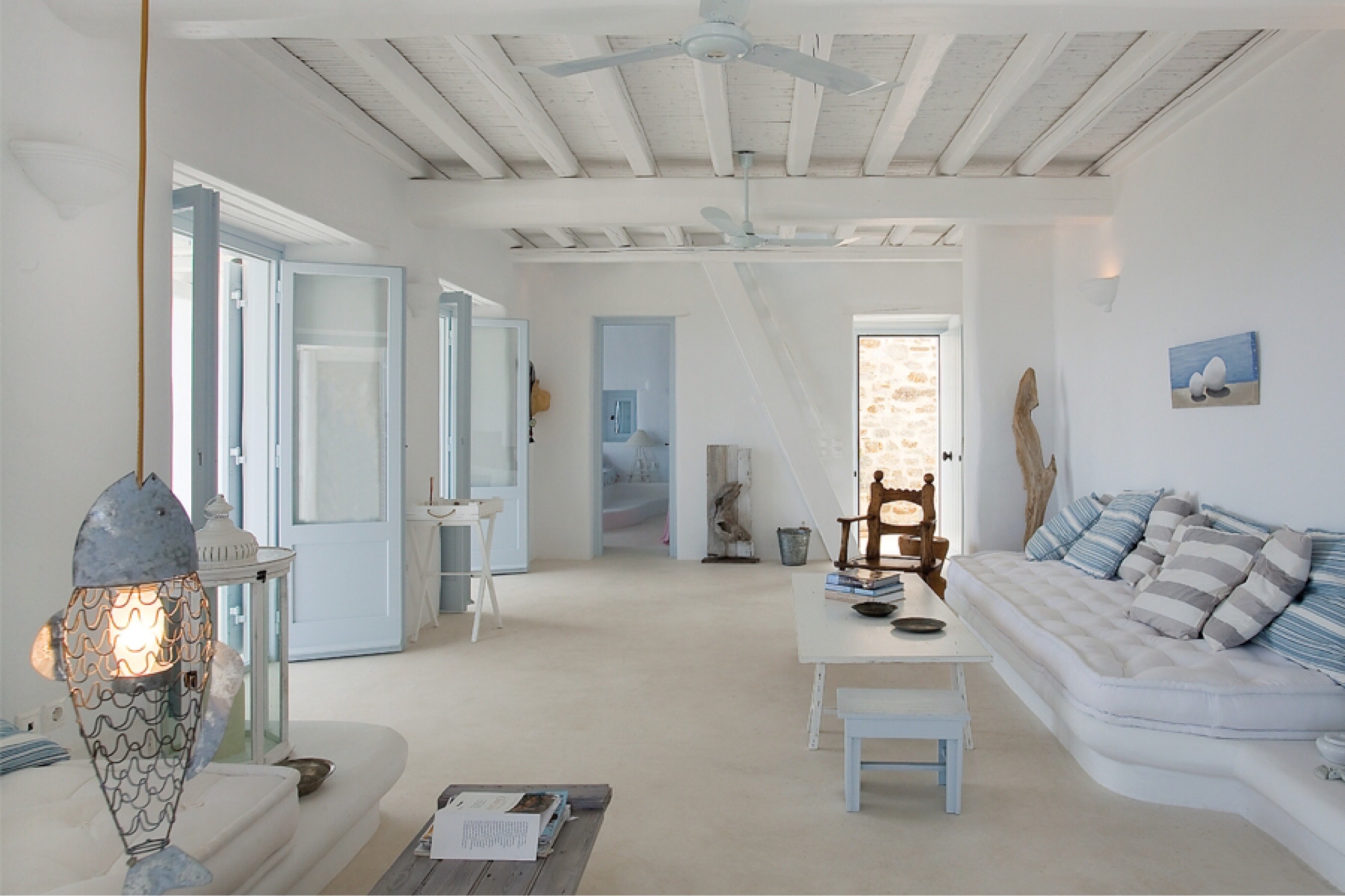 Interno luminoso di una casa siciliana, con la luce naturale che attraversa gli ambienti