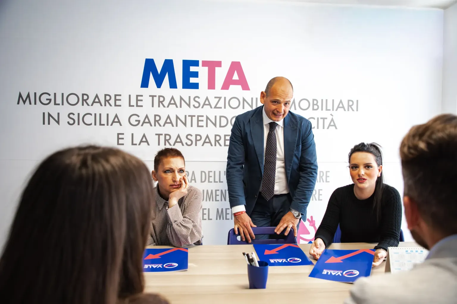 La squadra di Vale Immobiliare in riunione davanti al muro della Meta aziendale